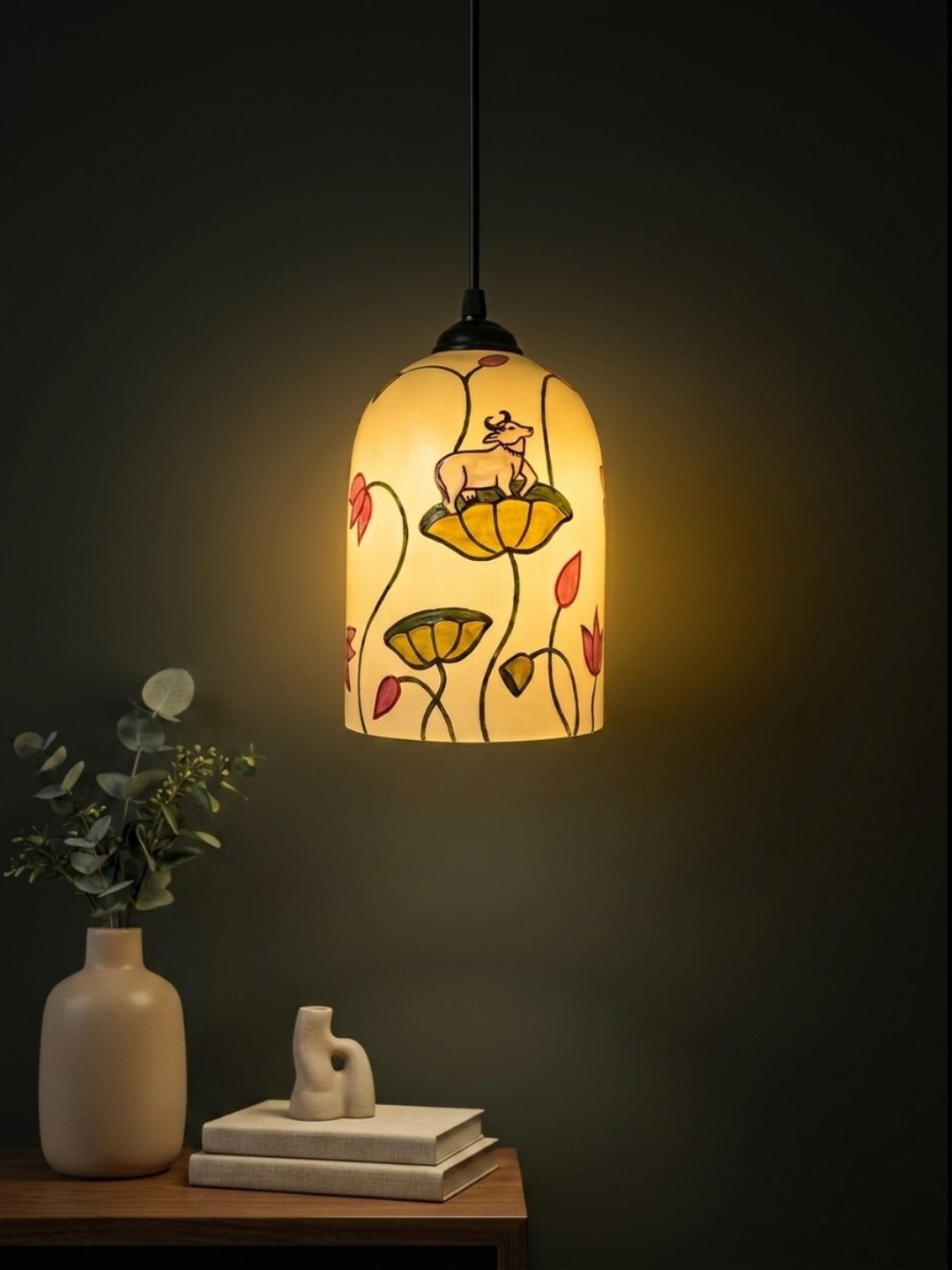 Hand-painted cylindrical glass pendant light featuring traditional Pichwai cow and lotus motif